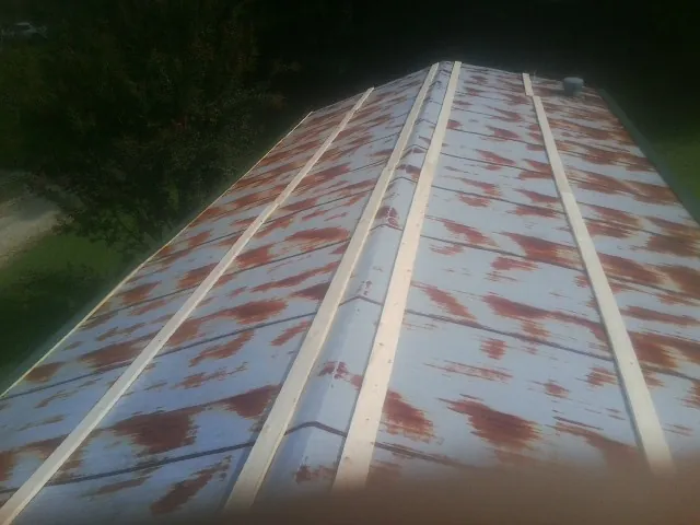 Rusted metal roof panels with new wood purlins before replacement — Storm Damage Roof Repair in Cedarbluff by Roofing Brothers